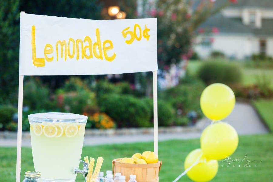 kid's lemonade stand set up on front yard in neighborhood