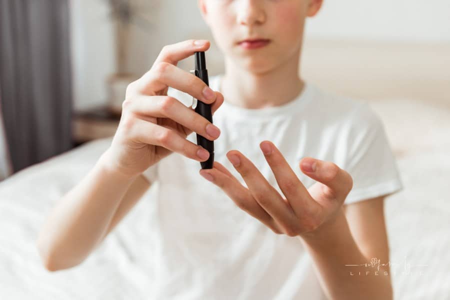 teen using a glucometer to check blood sugar levels for diabetes