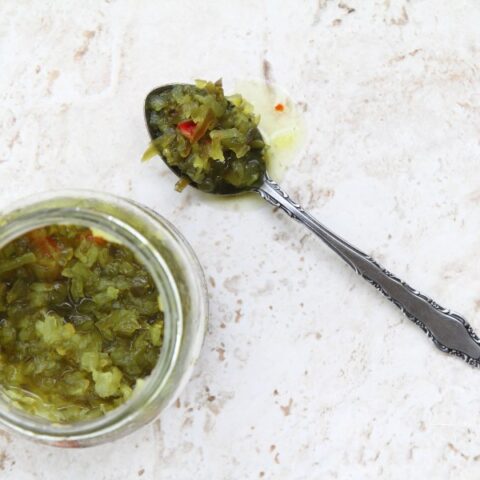 Pickle relish in jar with spoonful on side