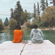 teens sitting on a river dock