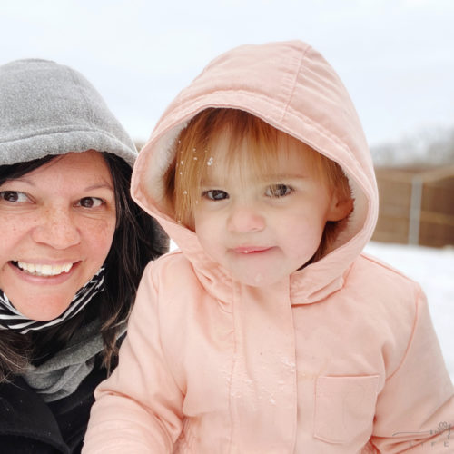 grandma and toddler posing in snow with hoodies