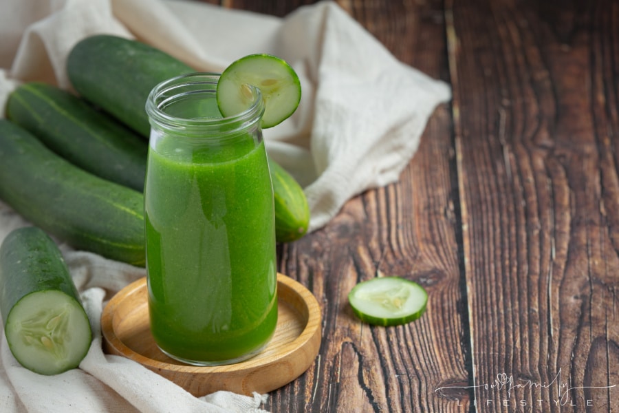 fresh cucumber juice in a jar on dark wood background