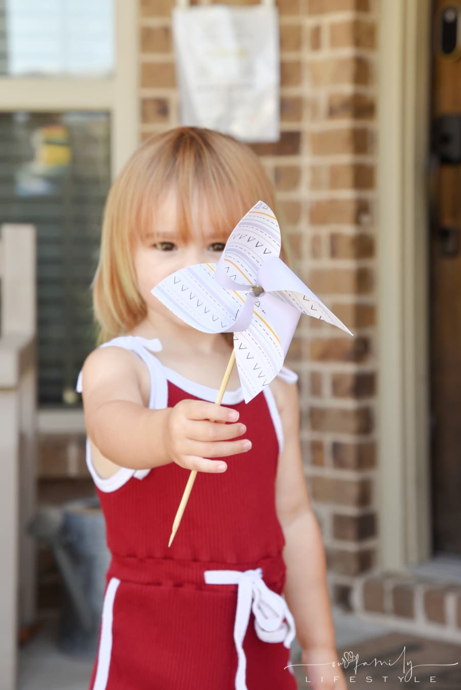 toddler holding DIY pinwheel