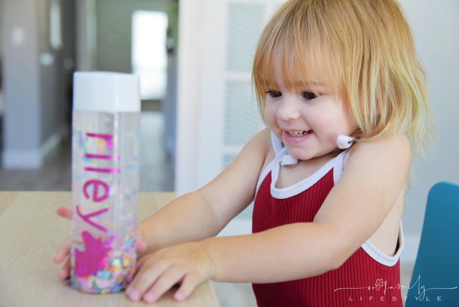 toddler playing with personalized calm down jar