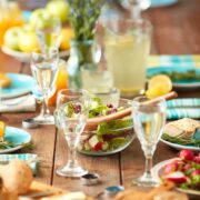 wooden table set with teal napkins and tableware with lemonade glasses