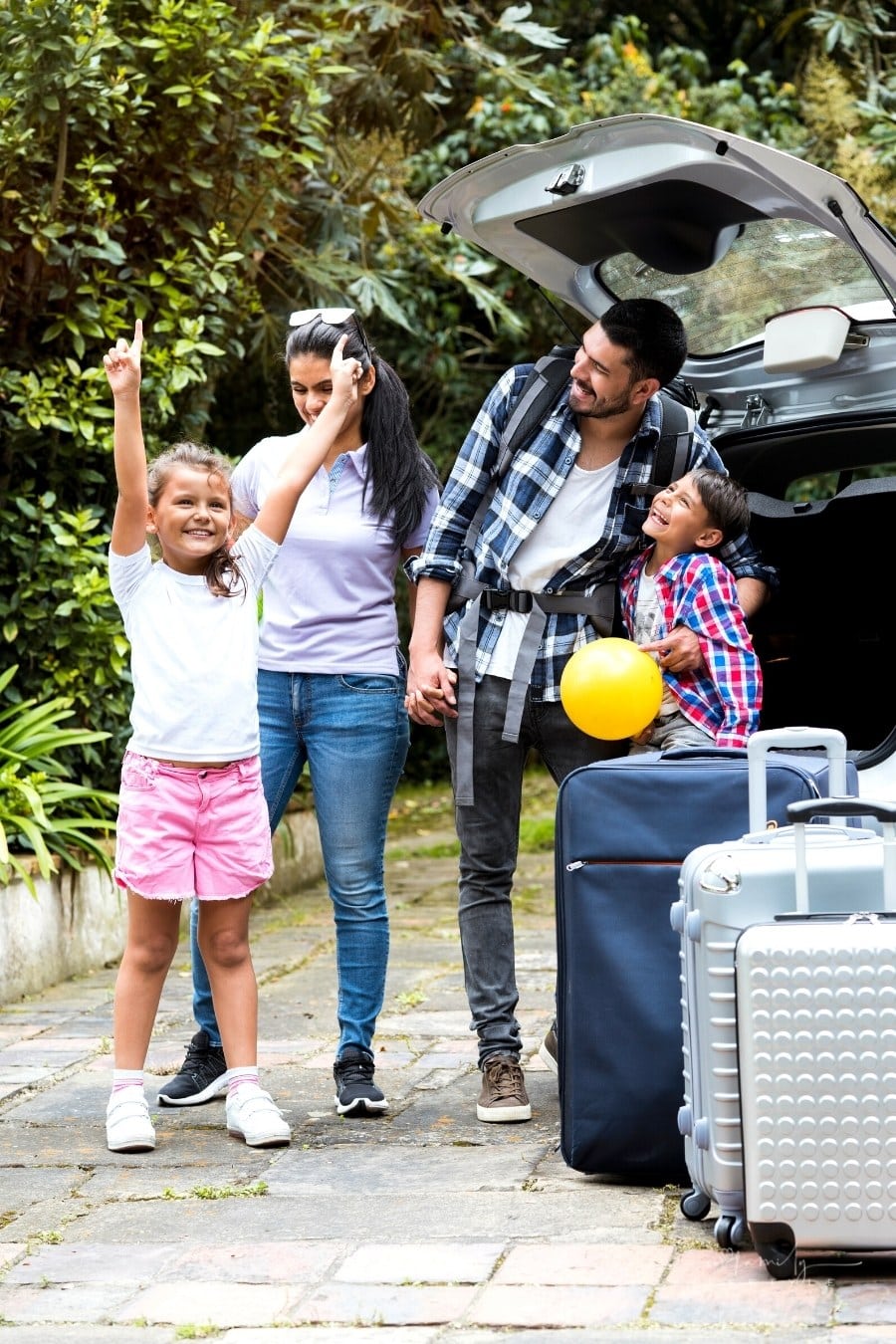 family loading luggage into back of SUV for road trip