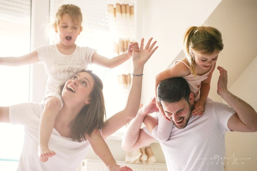 happy family having a pillow fight on bed