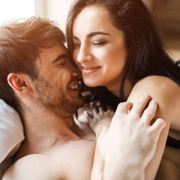 young couple laughing in bed