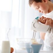 young boy using mixer in kitchen