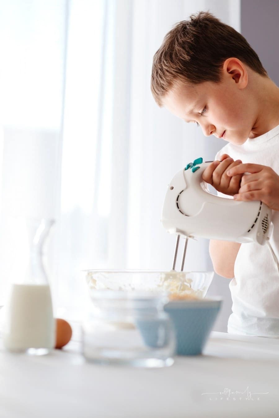 young boy using mixer in kitchen