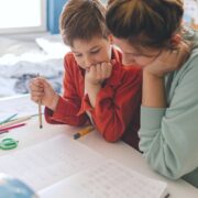 mom and young son working together on homeschool assignment