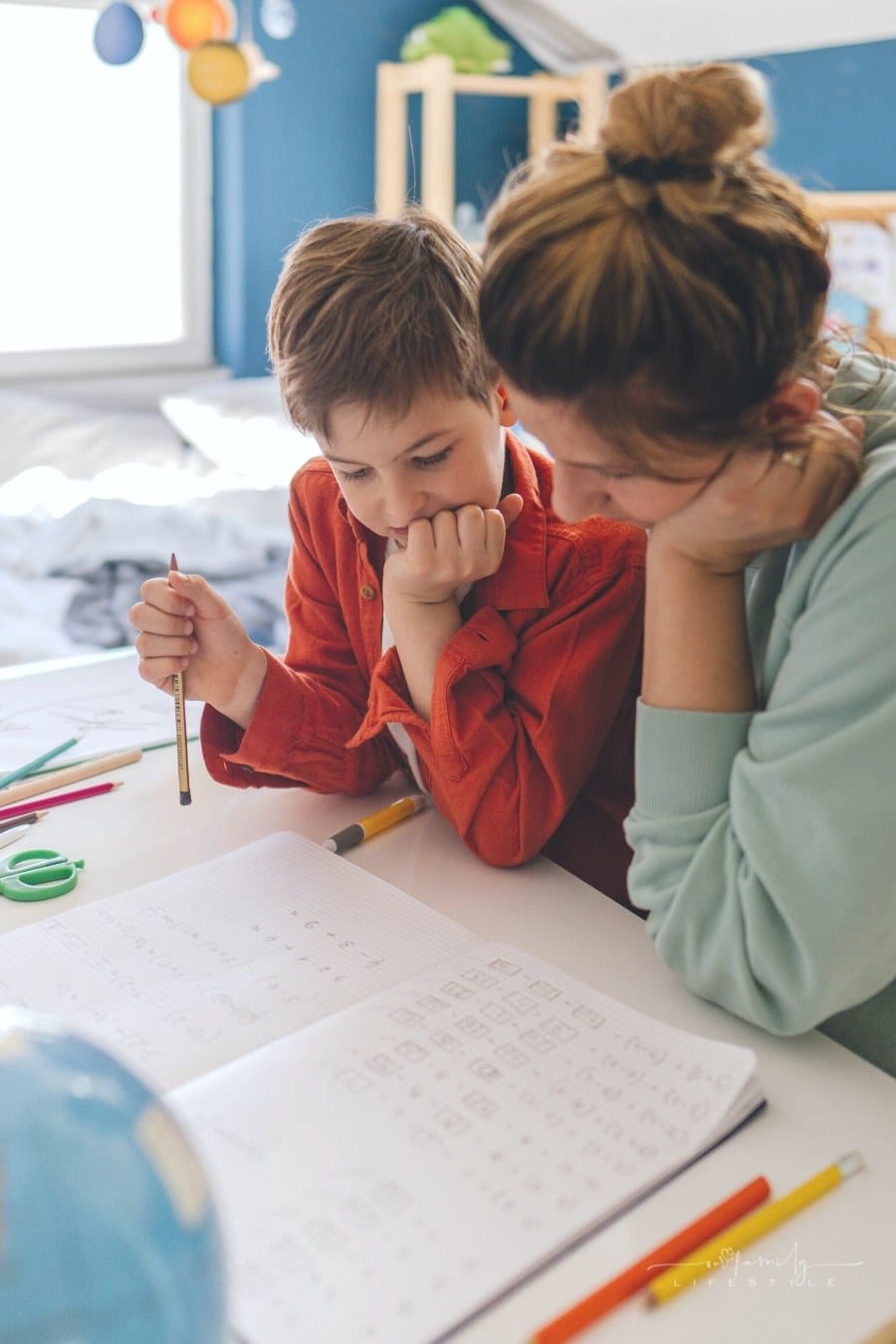 mom and young son working together on homeschool assignment