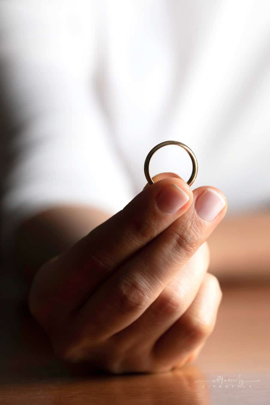 woman holding wedding band in her fingers