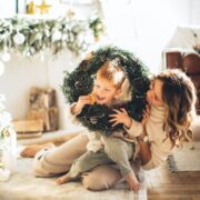 mother and child playing with a Christmas wreath