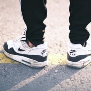 perso wearing black joggers with white and black Nike sneakers