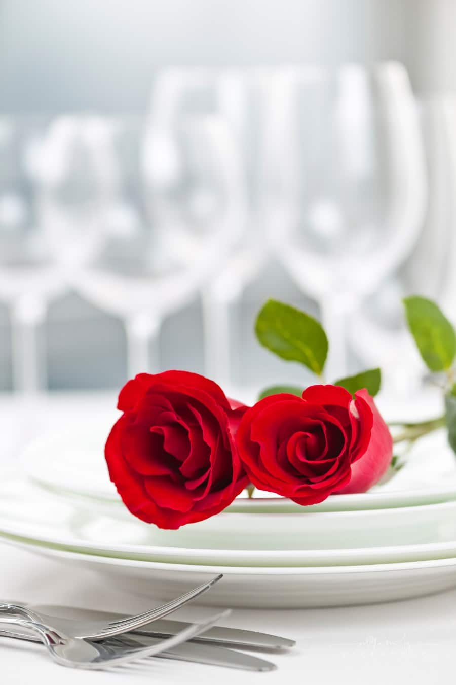 romantic dinner table with roses and champagne flutes