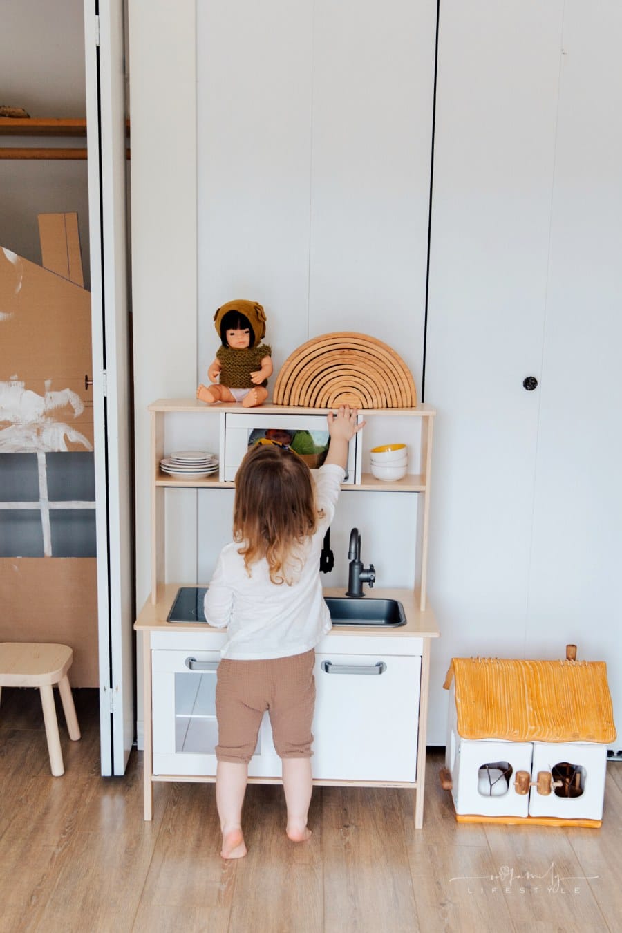 small child playing in pretend kitchen