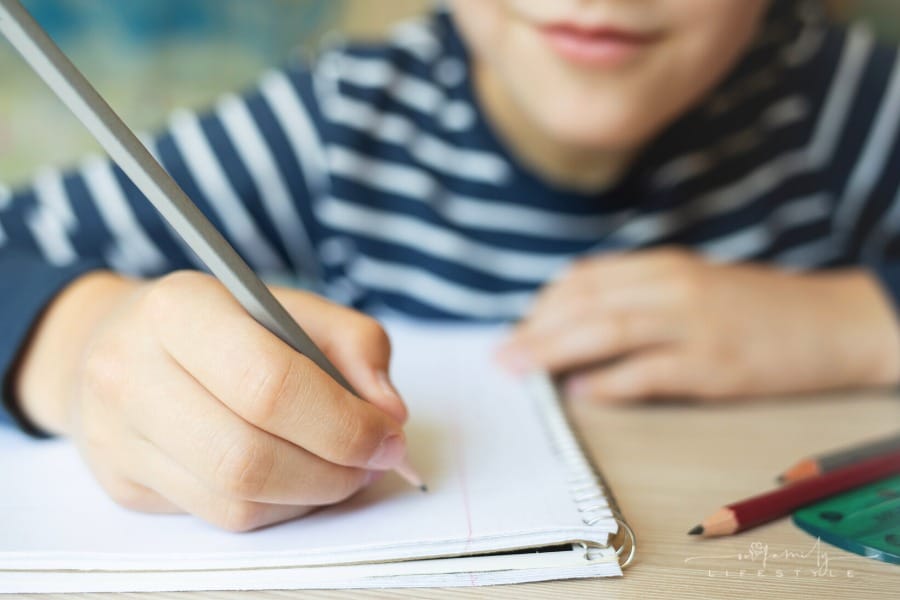 child writing thoughts in a notebook