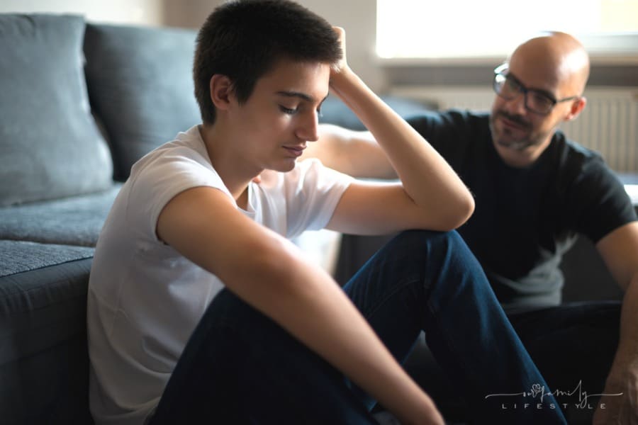 father talking to upset teenage son about a serious topic
