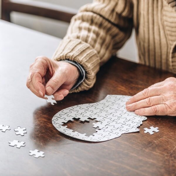 senior dementia patient putting together a puzzle of a head