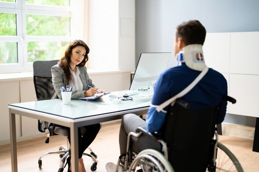 personal injury lawyer with injured male client in wheelchair