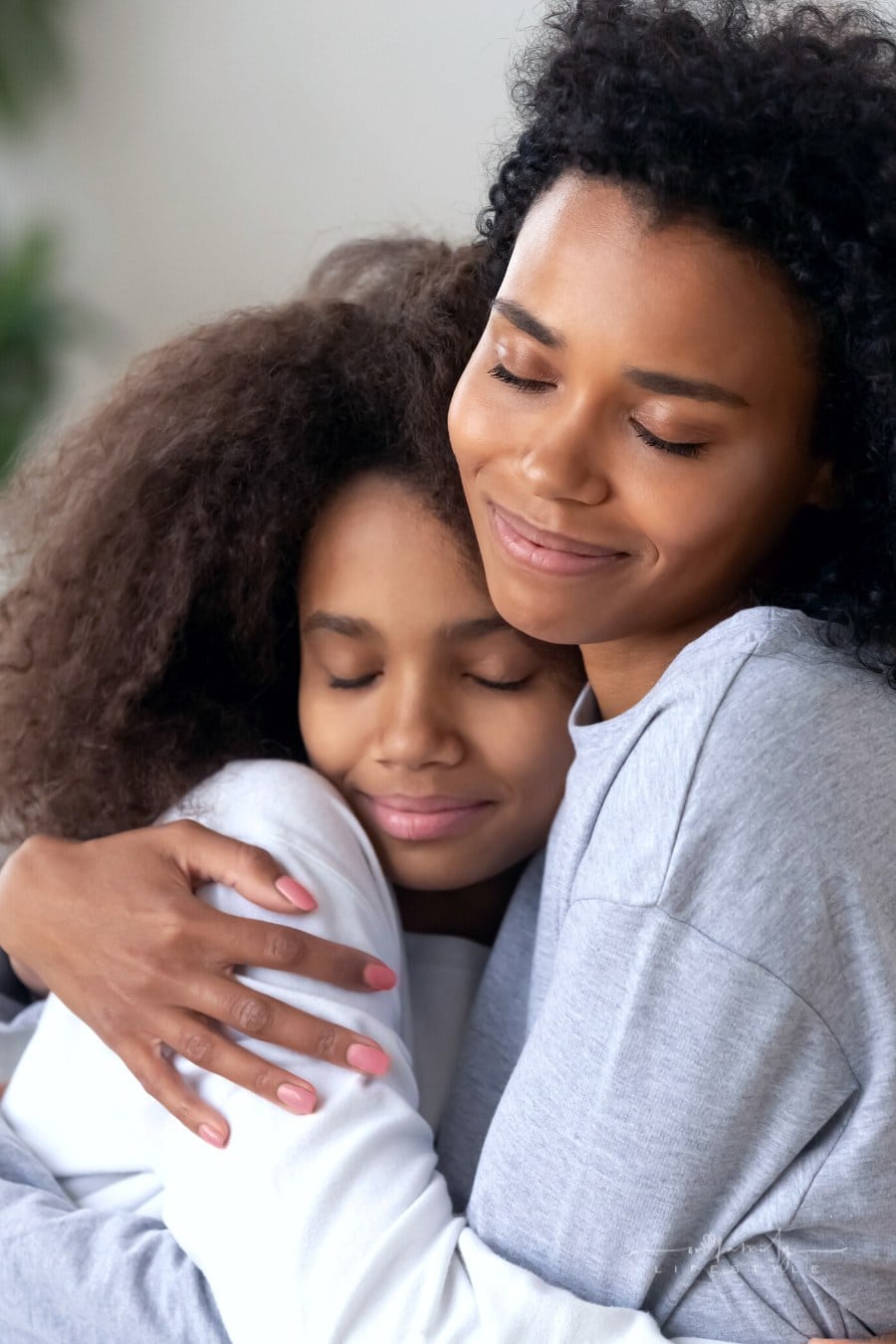 mom and teenage daughter hugging