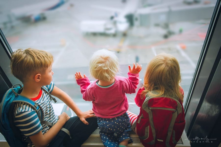 kids watching for plane in airport