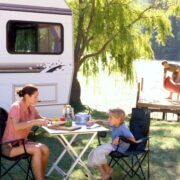 mom and son cutting vegetables at outdoor table while RV camping