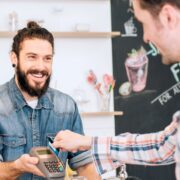 man paying vendor with mobile card reader at bakery