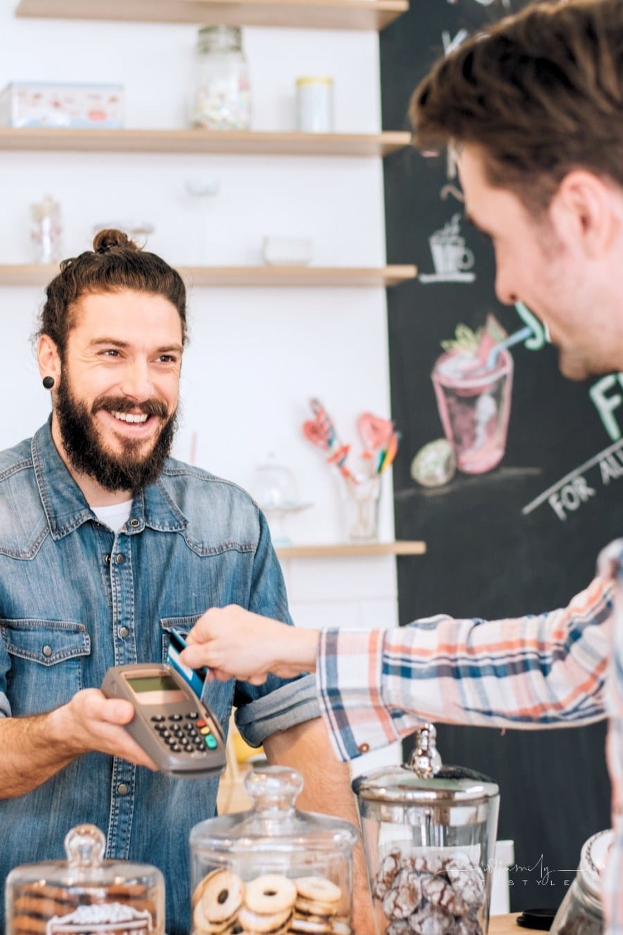 man paying vendor with mobile card reader at bakery