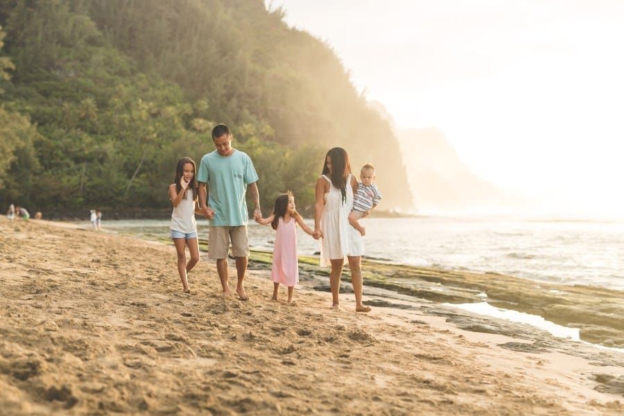 mom, dad, and three kids walking on a beach in Hawaii