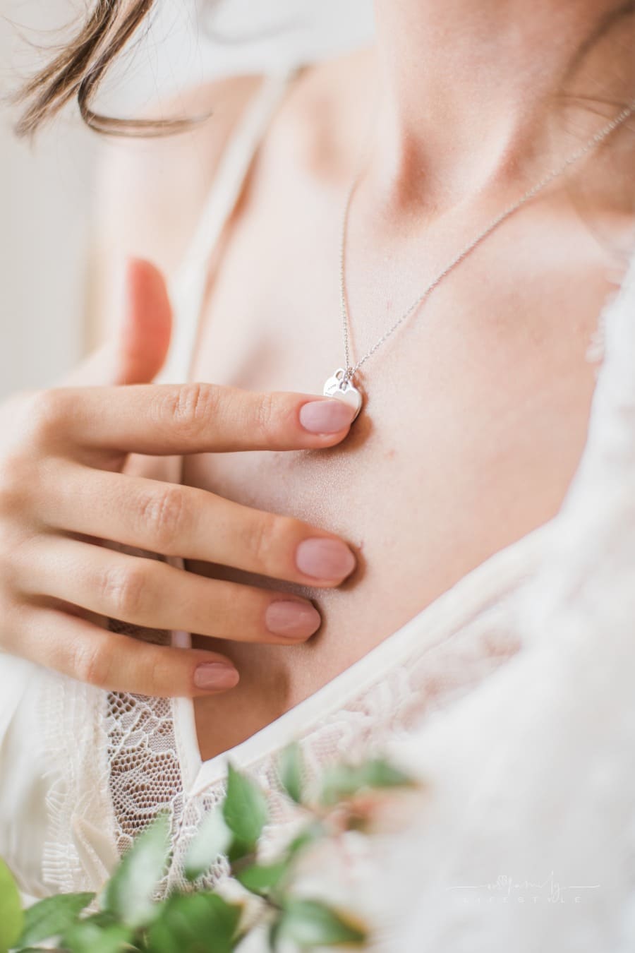 woman touching heart pendant necklace around her neck