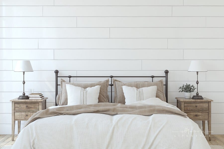 modern farmhouse bedroom with white shiplap accent wall and black iron bed frame