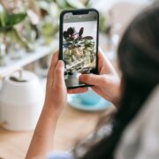 woman taking picture of potted plant with smartphone