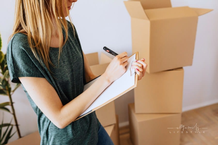 woman checking things of list as she prepares to move