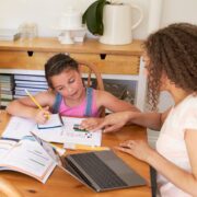 Parents Helping Children with Homeschooling work at Table