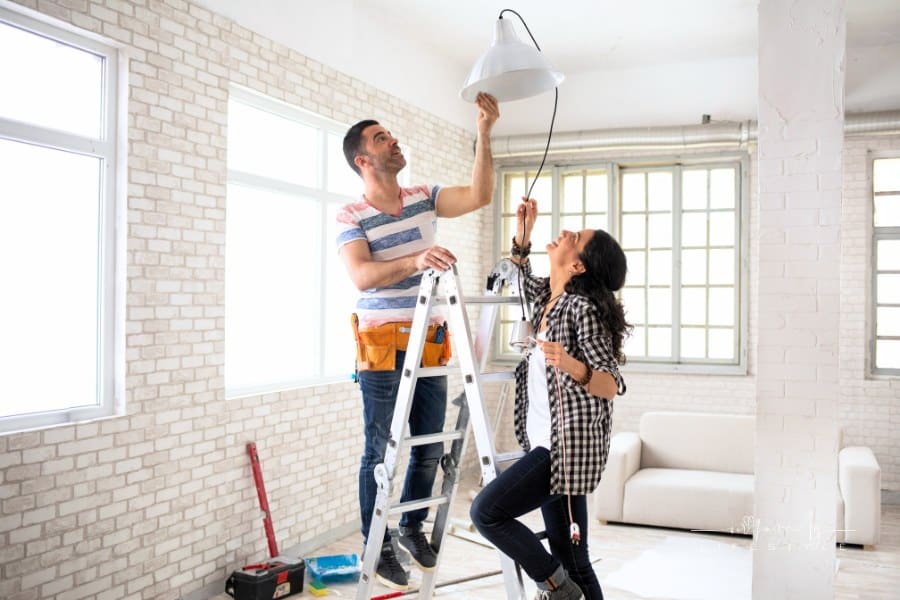 Couple renovating their home by adding new light fixture