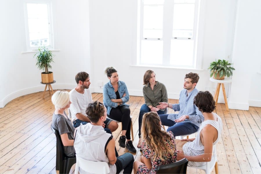 Man talking in group therapy session while others look on