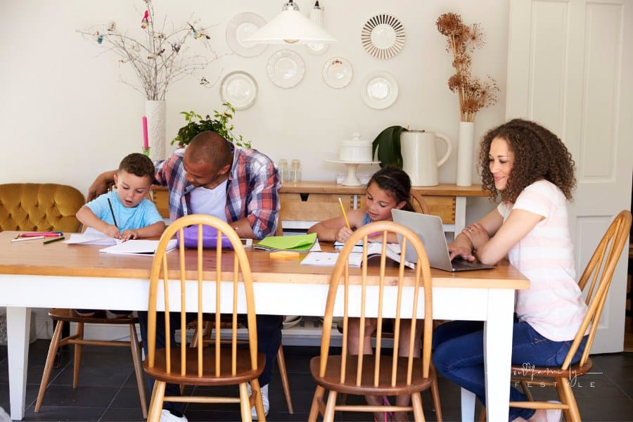 Parents Helping Children with Homeschooling work at Table