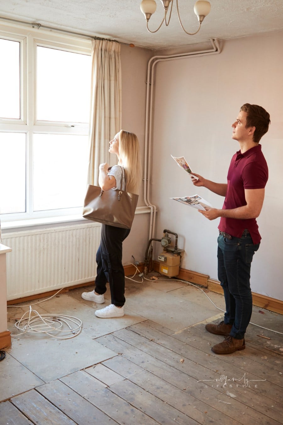 Couple Buying House for First Time Looking at House Survey in Room to be renovated