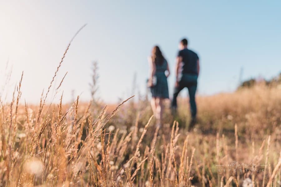 A Couple Walking in a Field of Grass