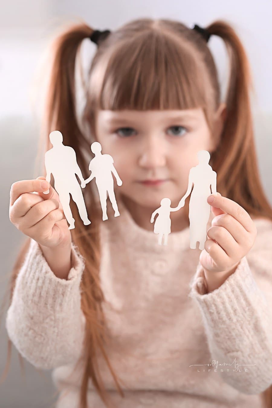 Little Girl Holding Broken Figure of Family at Home. Divorce Concept