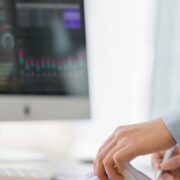 Cropped shot of businesswoman accountant sifting through stacks of paper files and folders. The analyst working on a business analytics dashboard, utilizing KPI, charts, and metrics to analyze data.