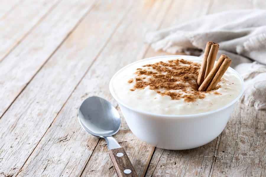 Arroz con leche. Rice pudding with cinnamon in bowl on wooden table