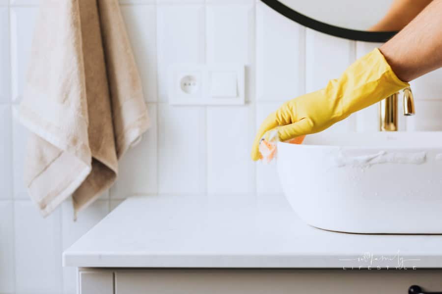 Unrecognizable person washing sink in bathroom