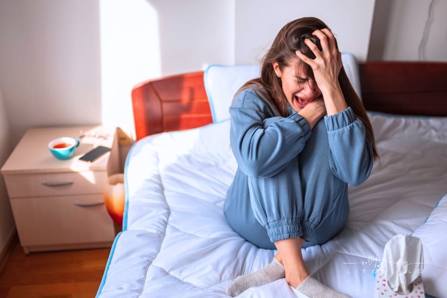 Anxious woman crying in bed