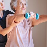 Senior Woman Using Dumbbells with Physiotherapist