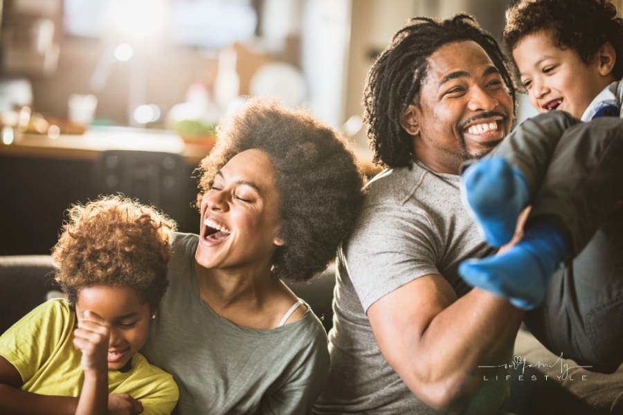 Joyful African American family having fun in the living room.