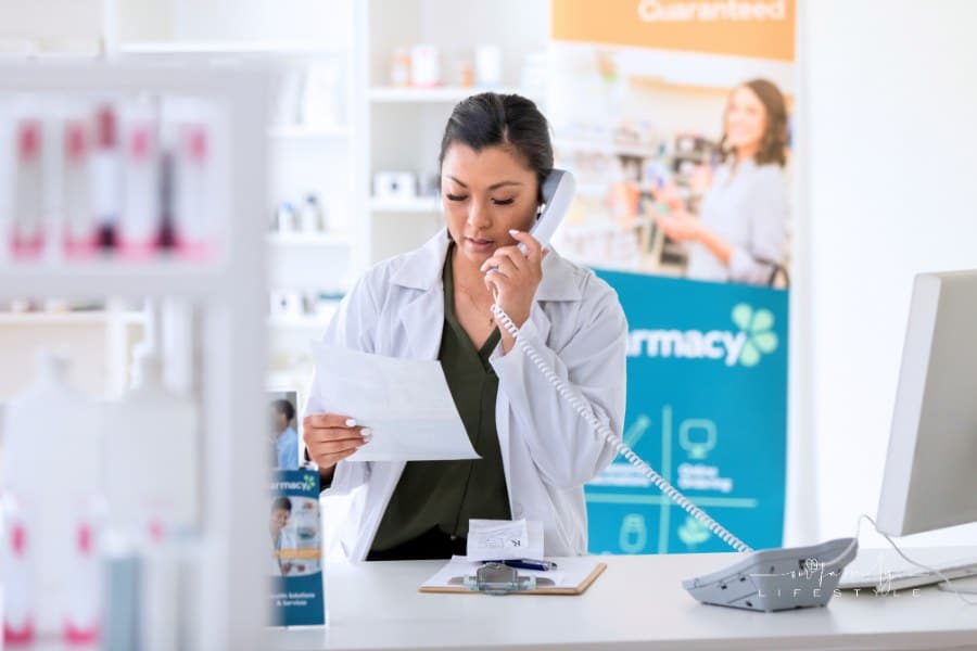 Female pharmacist uses telephone